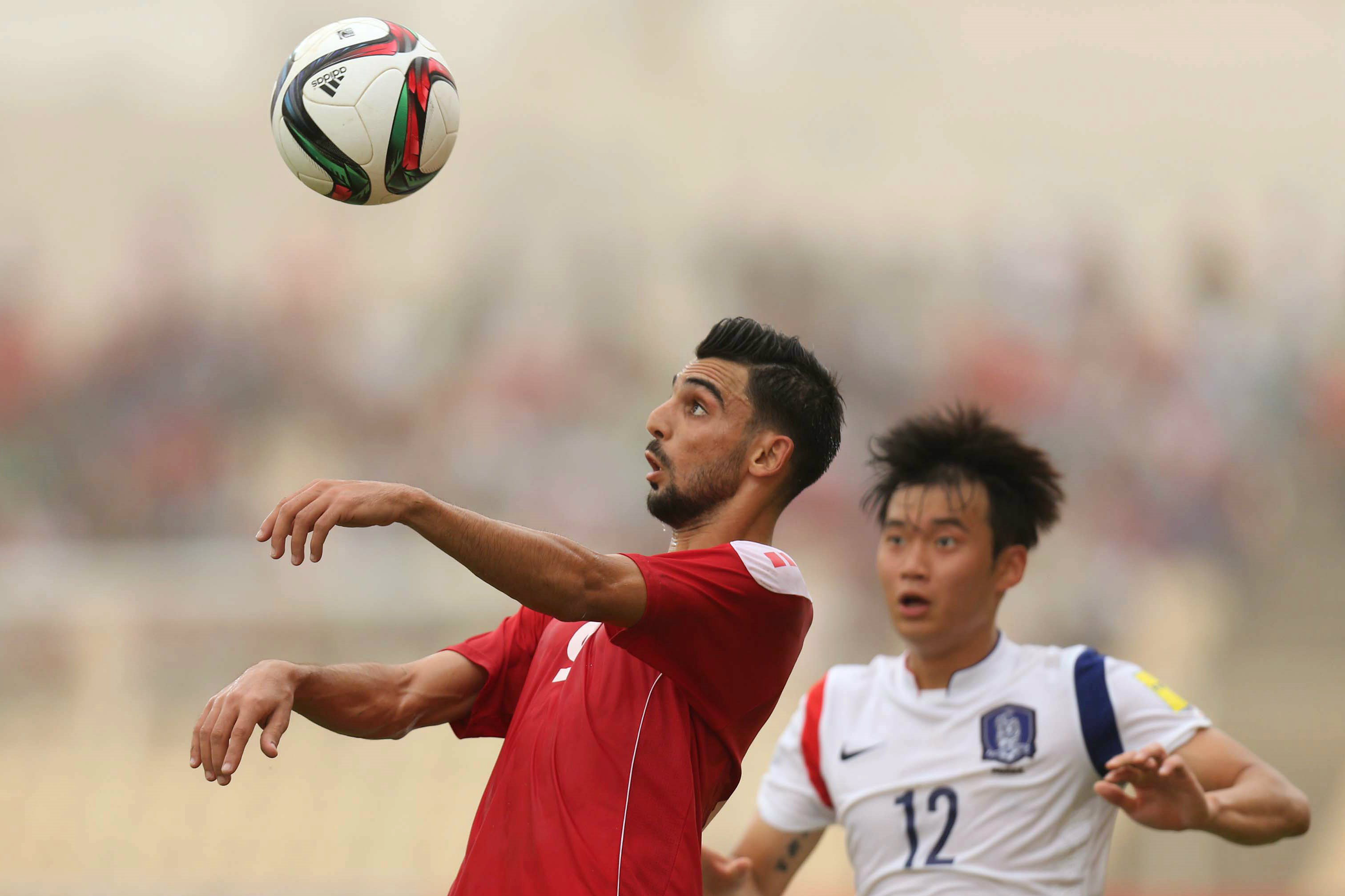 Mohamed Haider heads the ball against Korea Republic.