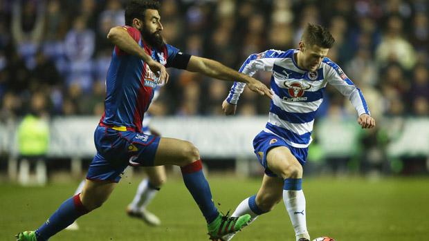 Crystal Palace skipper Mile Jedinak challenges for the ball with Reading's Oliver Norwood.