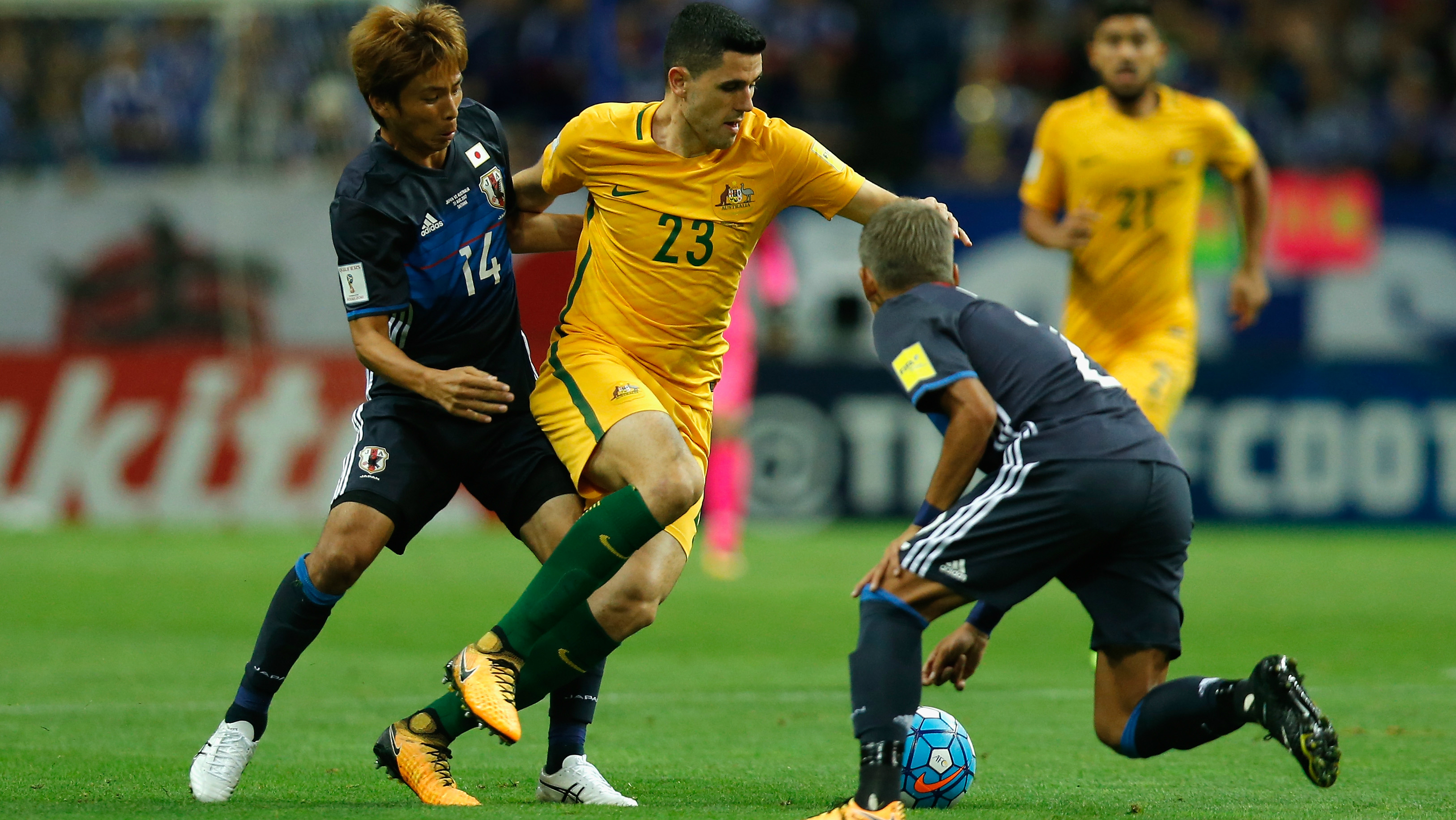 Caltex Socceroos playmaker Tom Rogic looks to take on a couple of Japanese defenders.