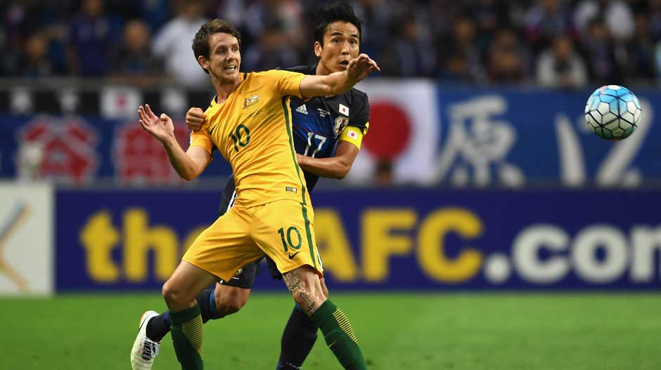 Robbie Kruse in a tussle for possession with his Japanese defender.