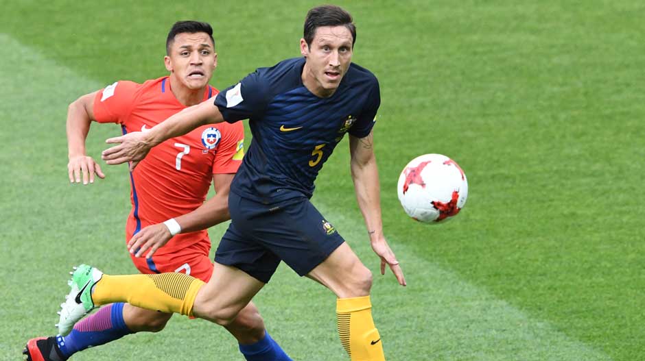 Caltex Socceroos defender Mark Milligan gets to the ball ahead of Chile's Alexis Sanchez.
