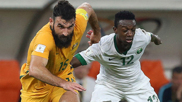 Caltex Socceroos captain Mile Jedinak challenges Saudi Arabia's Hassan Fallatah for the ball.