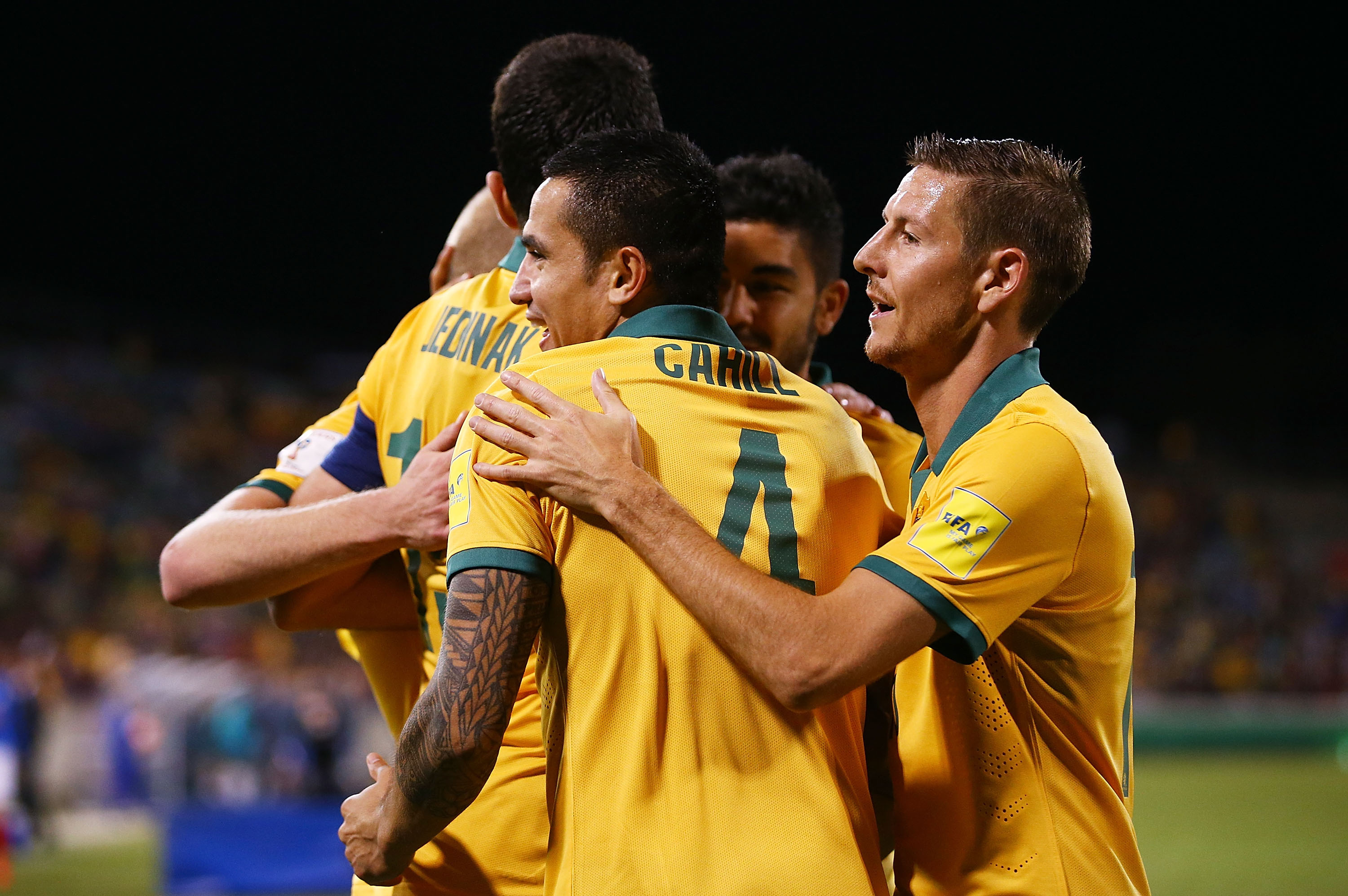 Tim Cahill celebrates with teammates after netting Australia's second goal against Kyrgyzstan in Canberra.