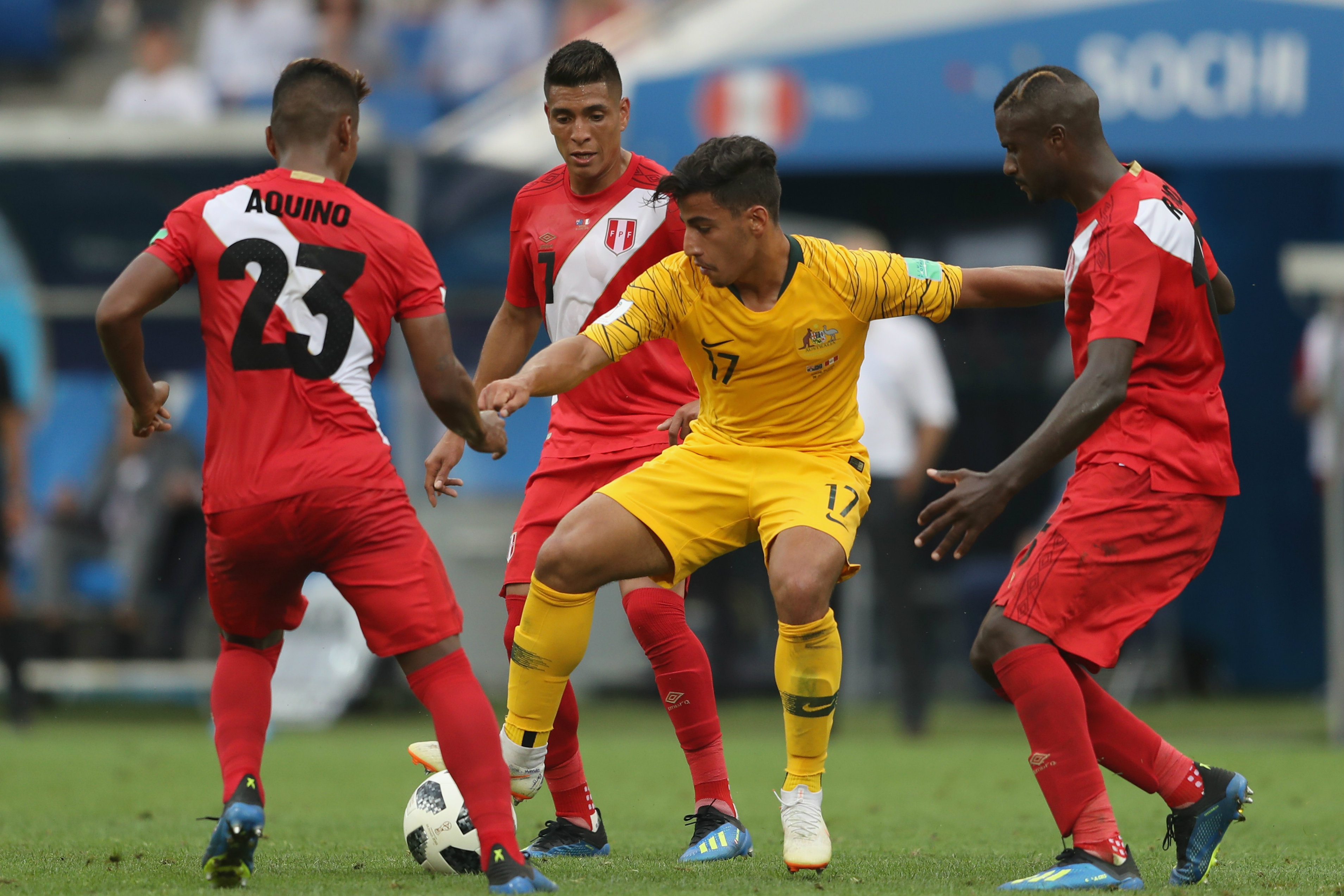Three Peruvian players surround Daniel Arzani in the game in Sochi. Three Peruvian players surround Daniel Arzani in the game in Sochi.