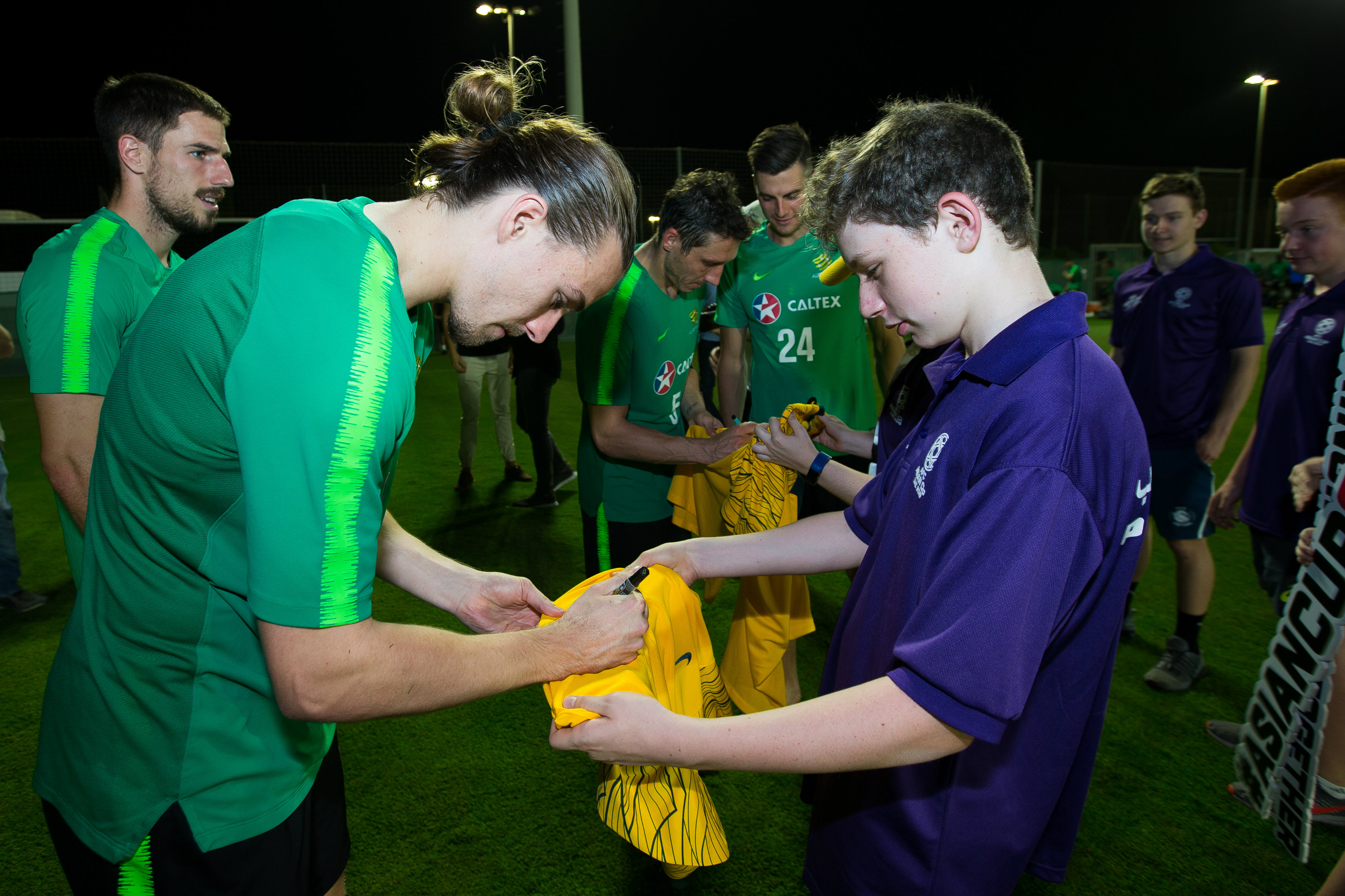 Jackson Irvine signs a jersey for a young fan. Jackson Irvine signs a jersey for a young fan.