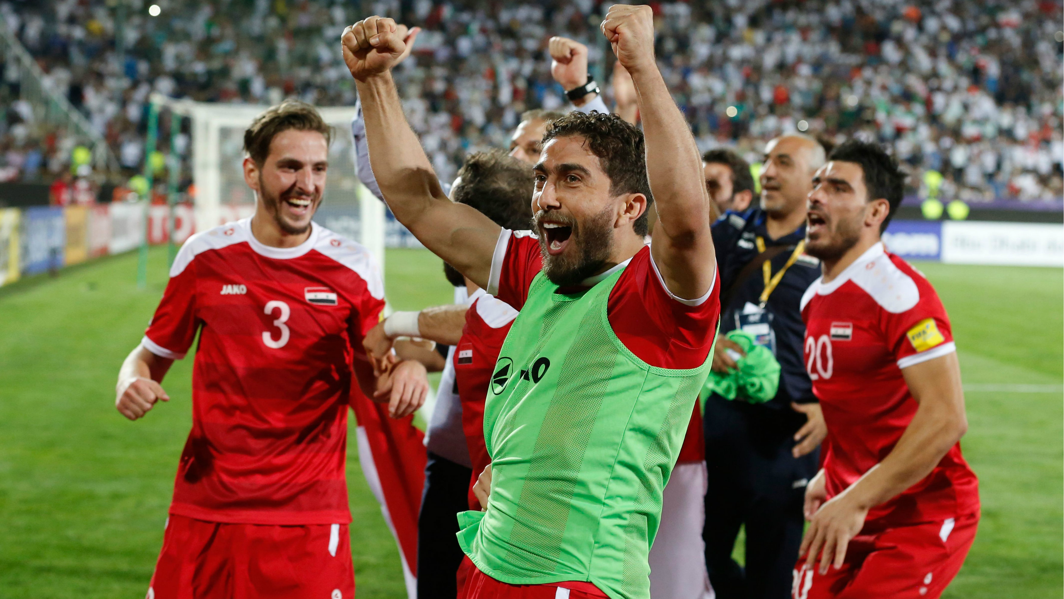 Syria players celebrate their 2-2 draw with Iran, which set up the clash with the Caltex Socceroos.