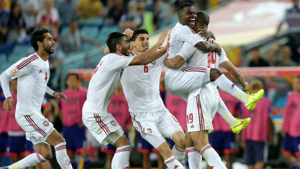 UAE's Ismail Ahmed celebrates converting the winning penalty against Japan with teammates.