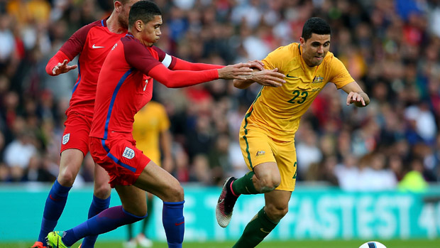 Socceroos playmaker Tom Rogic fights for the ball with England captain Chris Smalling.