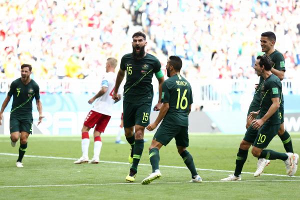 The Socceroos get around skipper Mile Jedinak after his penalty.