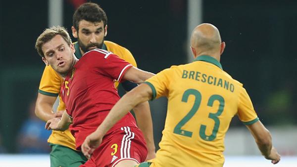 Mile Jedinak and Mark Bresciano challenge Belgium's Nicolas Lombaerts for the ball.