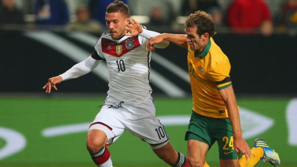 Luke DeVere challenges Germany striker Lukas Podolski.