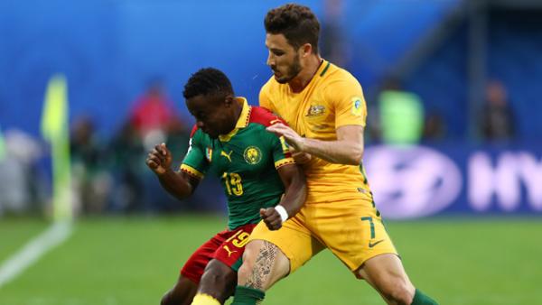 Socceroos star Mat Leckie challenges for the ball with Cameroon's Collins Fai.