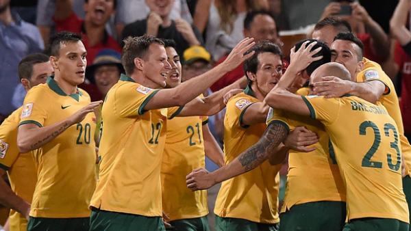 Socceroos players celebrate one of Tim Cahill's two goals against China PR.