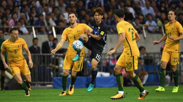 Four Caltex Socceroo surrond Japan attacker Yuya Osako.