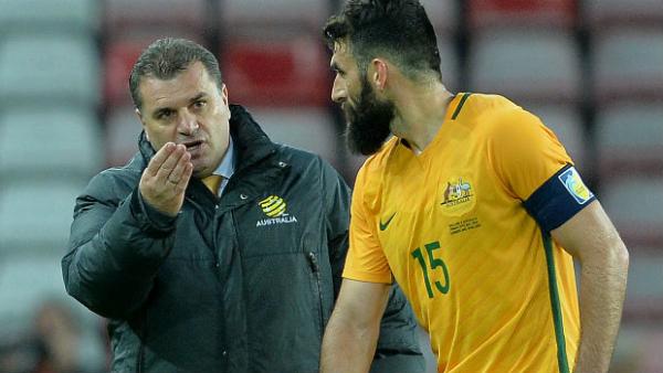 Caltex Socceroos captain Mile Jedinak receives instructions from coach Ange Postecoglou.