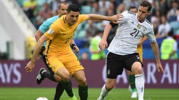 Tom Rogic fights for the ball with German captain Julian Draxler.