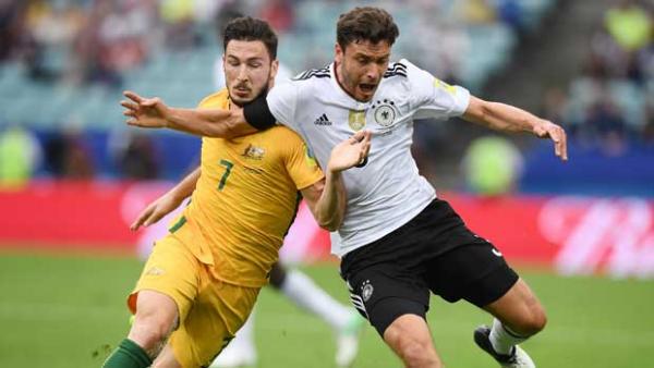 Caltex Socceroos winger Mat Leckie battles hard for possession with a German defender.