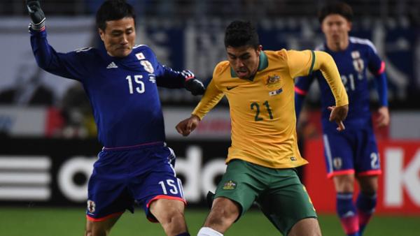 Socceroos midfielder Massimo Luongo fights for the ball with Japan's Yasuyuki Konno.