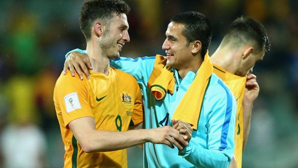 Apostolos Giannou is embraced by Socceroos talisman Tim Cahill following Australia's win over Tajikistan.