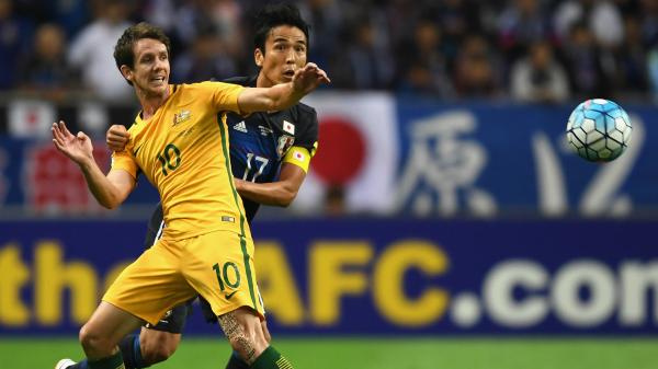 Robbie Kruse gets man-handled by his Japanese defender during the Caltex Socceroos 2-0 loss in Saitama.