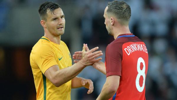 Bailey Wright shakes hands with England midfielder Danny Drinkwater.
