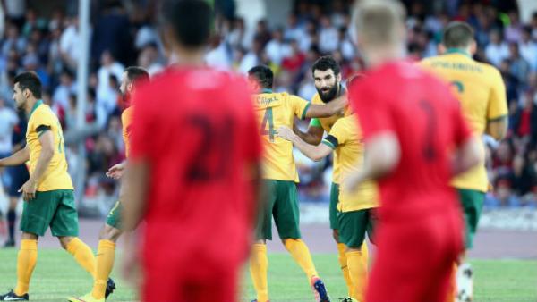 Mile Jedinak is embraced by teammates after scoring the Socceroos opener.